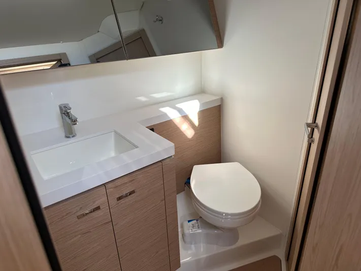  Yacht Photos Pics Modern bathroom in 2023 Beneteau First 53 yacht with sink and toilet.