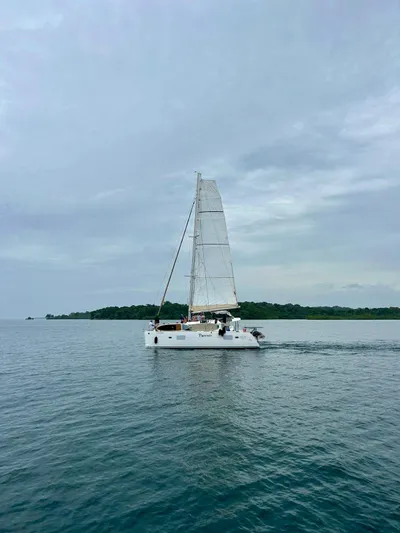  Yacht Photos Pics Sailing catamaran Lagoon 400, 2010 model, cruising on calm waters near a lush island.