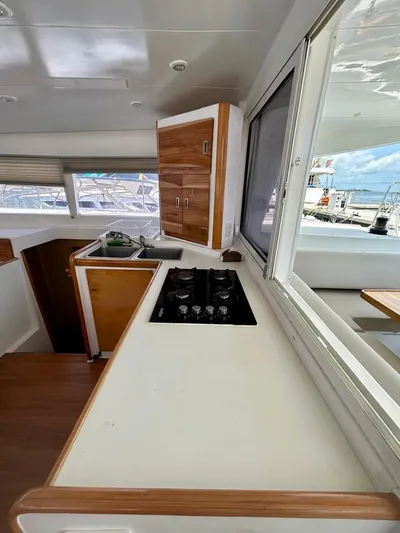  Yacht Photos Pics Interior of 2010 Lagoon 400 yacht kitchen with stove, sink, and wooden cabinets.