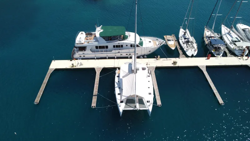  Yacht Photos Pics Aerial view of a 2023 Lagoon 42 catamaran docked at a marina.