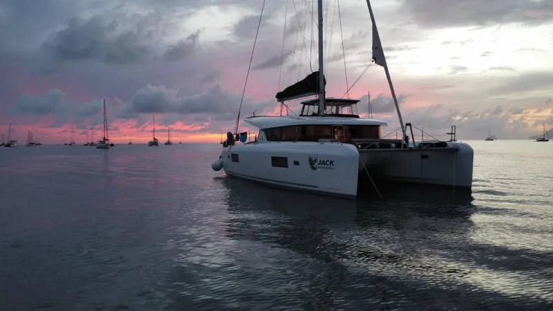  Yacht Photos Pics 2023 Lagoon 42 catamaran at sunset, anchored in calm waters.