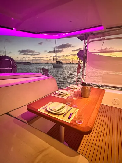  Yacht Photos Pics 2023 Lagoon 42 yacht interior with elegant dining setup at sunset.