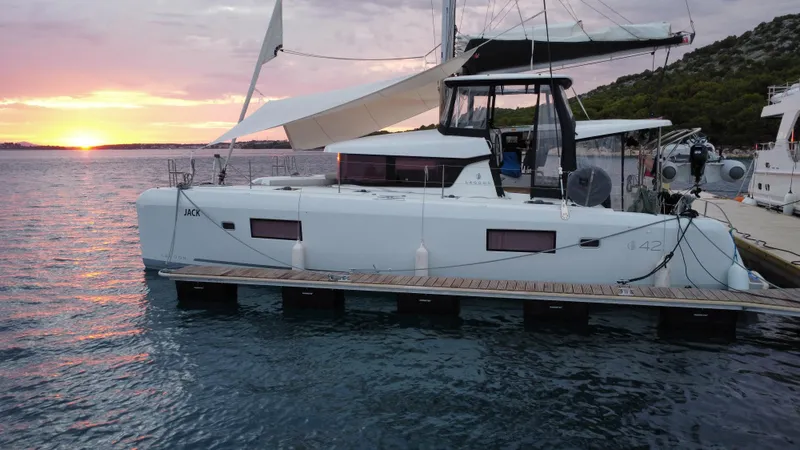  Yacht Photos Pics 2023 Lagoon 42 catamaran docked at sunset, featuring sleek design and modern amenities.