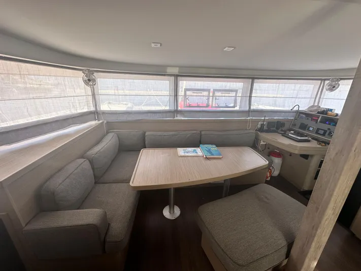  Yacht Photos Pics Interior of 2023 Lagoon 42 catamaran with cozy seating and navigation station.