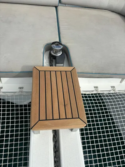  Yacht Photos Pics Teak deck detail on 2023 Lagoon 42 catamaran with cushioned seating and netting.