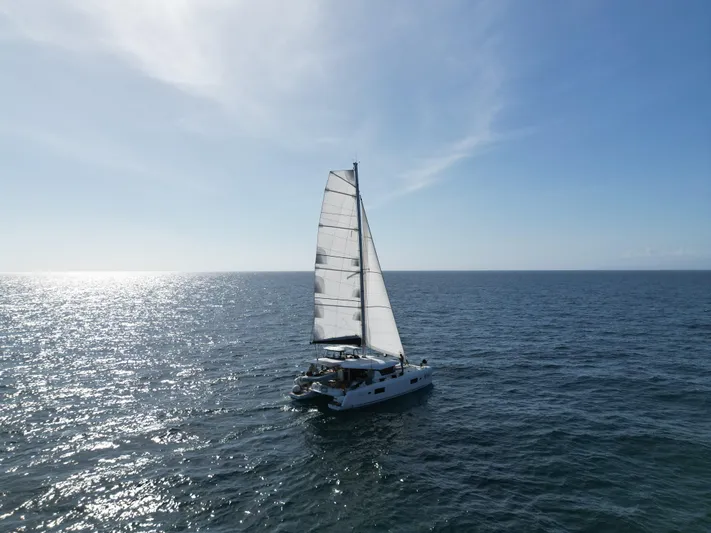  Yacht Photos Pics 2023 Lagoon 42 sailing on open sea under clear blue sky.