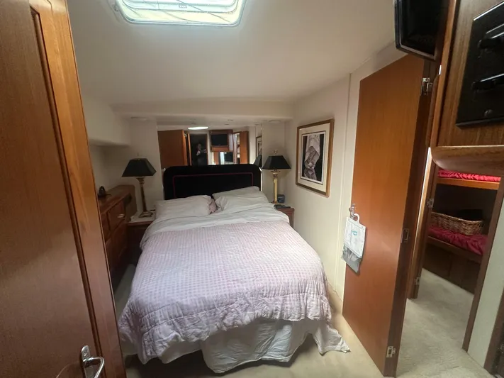  Yacht Photos Pics Cozy bedroom interior of 1998 Viking 53 Convertible yacht with double bed and wooden furnishings.