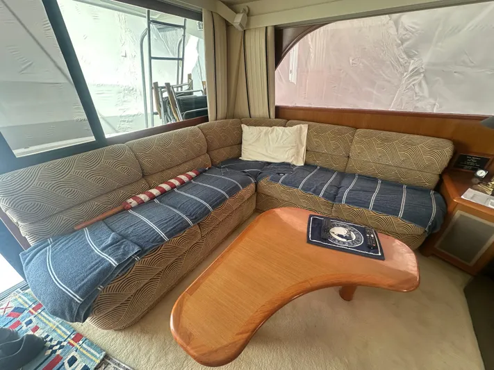  Yacht Photos Pics Cozy interior of 1998 Viking 53 Convertible yacht with L-shaped sofa and wooden table.