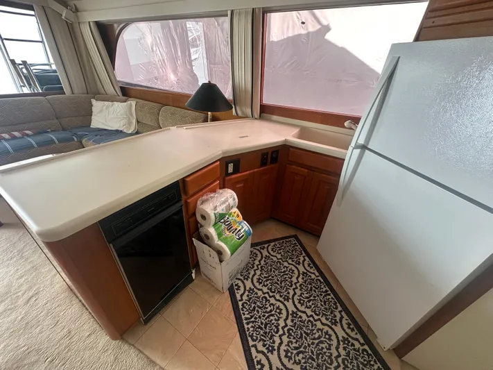  Yacht Photos Pics 1998 Viking 53 Convertible yacht interior with kitchen, counter, fridge, and seating area.