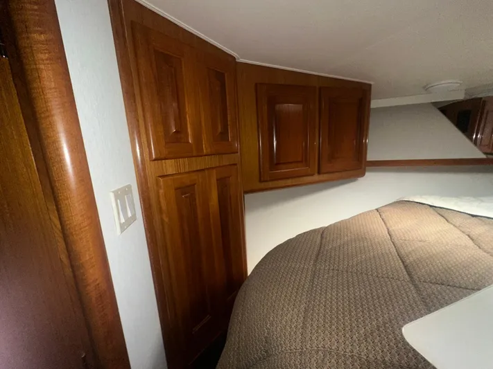  Yacht Photos Pics Interior of 1998 Viking 53 Convertible yacht with wooden cabinets and cozy bedding.