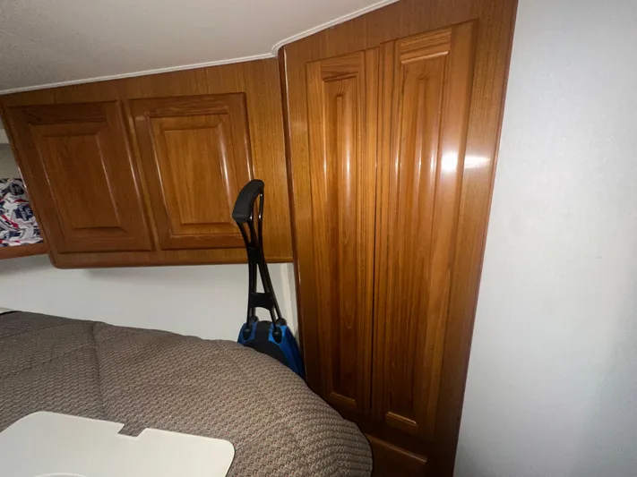  Yacht Photos Pics Interior of 1998 Viking 53 Convertible with wooden cabinets and cozy bedding.