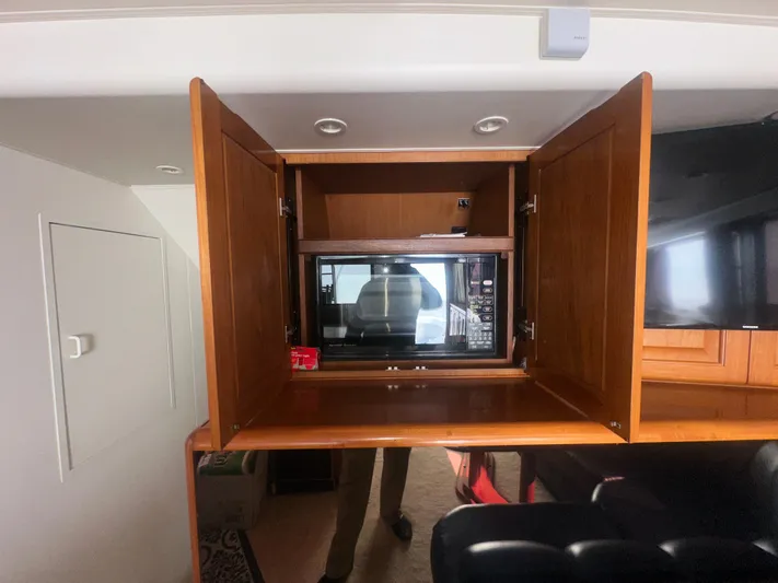  Yacht Photos Pics 1998 Viking 53 Convertible interior with open wooden cabinet and built-in microwave.