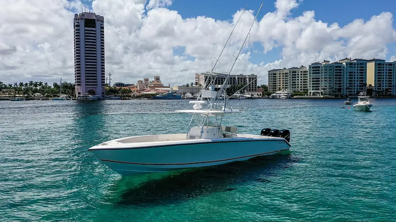  Yacht Photos Pics 2005 Venture 39 Open boat on clear blue water with city skyline background.