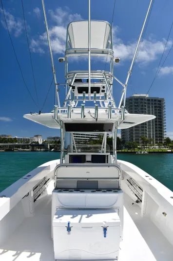  Yacht Photos Pics 2005 Venture 39 Open boat on water, clear sky, modern buildings in background.