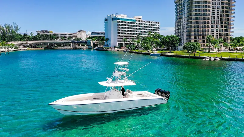  Yacht Photos Pics 2005 Venture 39 Open boat on turquoise water near cityscape.