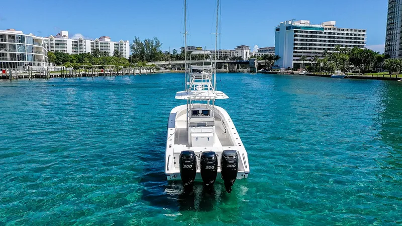  Yacht Photos Pics 2005 Venture 39 Open boat with triple engines on clear blue water.