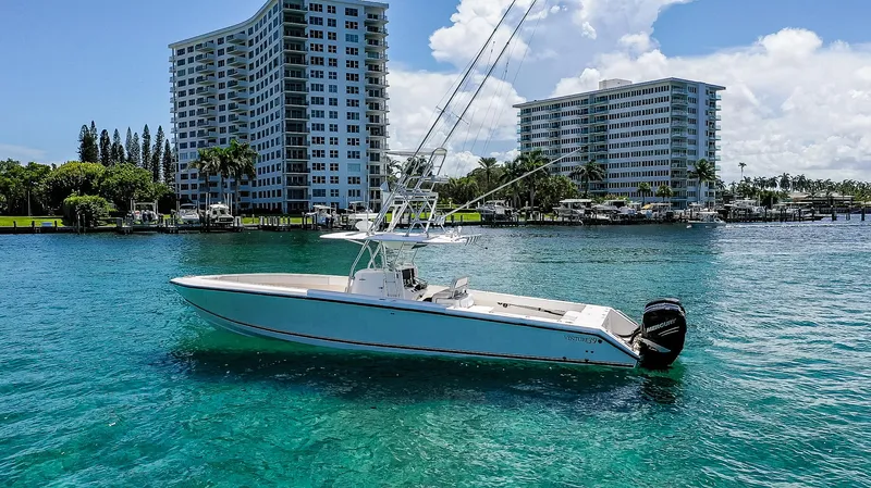  Yacht Photos Pics 2005 Venture 39 Open boat on clear blue water near modern buildings.