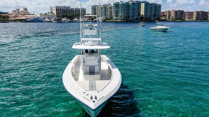  Yacht Photos Pics 2005 Venture 39 Open boat on clear blue water with city skyline background.