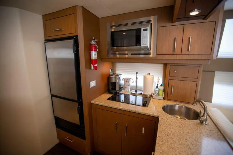 Tropical Life Yacht Photos Pics Compact kitchen in 2012 Carver Sojourn yacht with modern appliances and wood cabinetry.