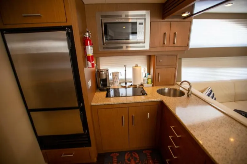Tropical Life Yacht Photos Pics Compact kitchen in 2012 Carver Sojourn yacht with modern appliances and wooden cabinetry.