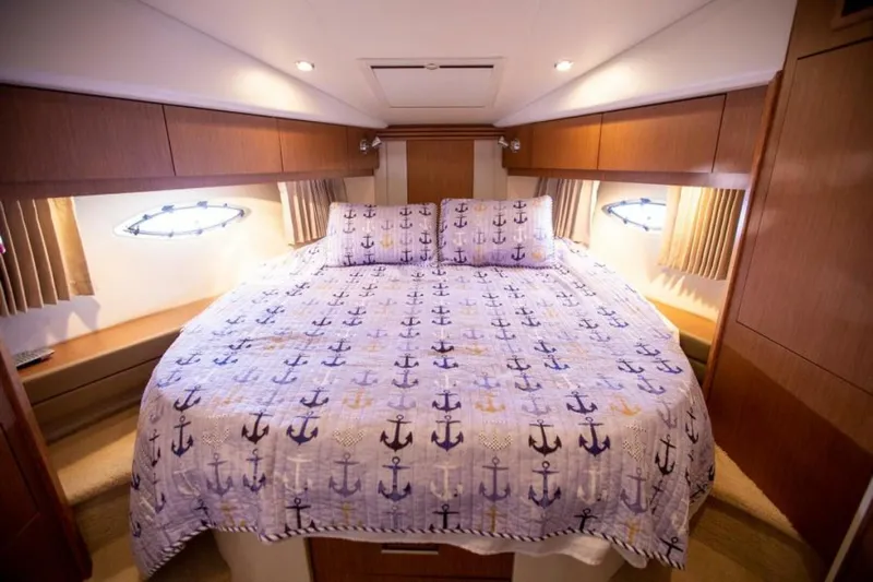 Tropical Life Yacht Photos Pics Luxurious 2012 Carver Sojourn cabin with anchor-themed bedding and elegant wood paneling.
