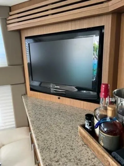 Tropical Life Yacht Photos Pics Flat-screen TV in 2012 Carver Sojourn yacht interior with granite countertop and liquor bottles.