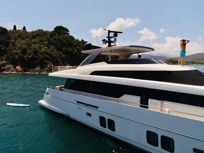 Sanlorenzo Sl96 Yacht Photos Pics Sanlorenzo SL96 yacht, 2016 model, anchored near a scenic coastline with a person on deck.