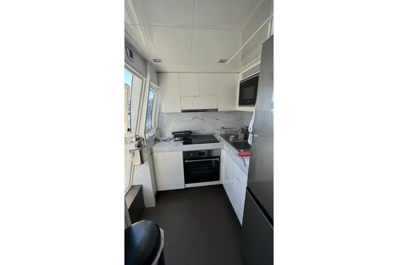  Yacht Photos Pics Modern kitchen interior on 2007 Astondoa A 76 GLX yacht, featuring sleek white cabinetry.