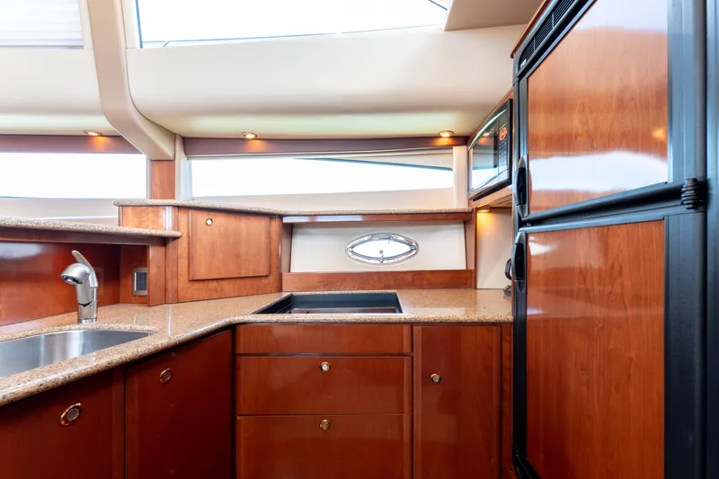 Summer Breeze Yacht Photos Pics Luxurious kitchen interior of 2008 Meridian 459 Motoryacht with wood cabinetry and modern appliances.