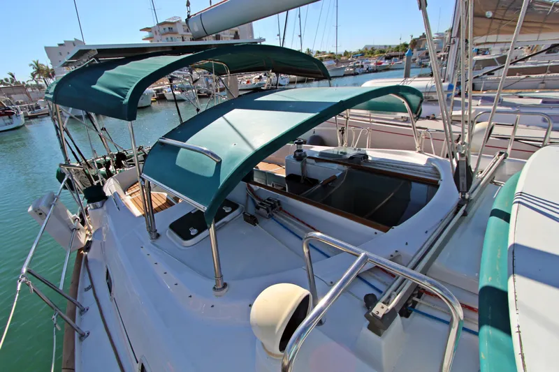 Oya Yacht Photos Pics 2001 Beneteau Oceanis 461 sailboat with green canopy, docked in a marina.