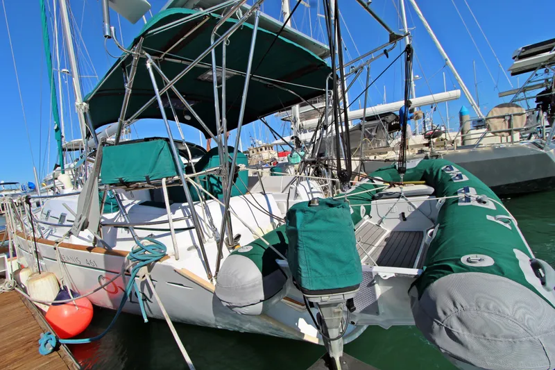 Oya Yacht Photos Pics 2001 Beneteau Oceanis 461 sailboat docked, featuring green covers and inflatable dinghy.