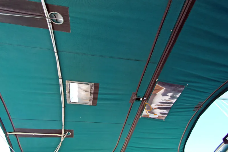 Oya Yacht Photos Pics Green canopy of a 2001 Beneteau Oceanis 461 sailboat, featuring metal supports.