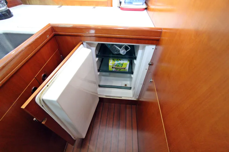 Oya Yacht Photos Pics Open fridge in 2001 Beneteau Oceanis 461 yacht kitchen, wooden cabinetry.