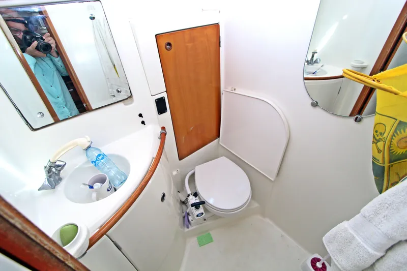 Oya Yacht Photos Pics Bathroom interior of 2001 Beneteau Oceanis 461 yacht, featuring sink, toilet, and mirror.