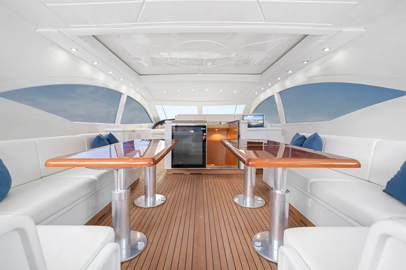 Gabriela G Yacht Photos Pics Luxurious interior of a 2001 Mangusta 72 yacht with elegant seating and wooden tables.