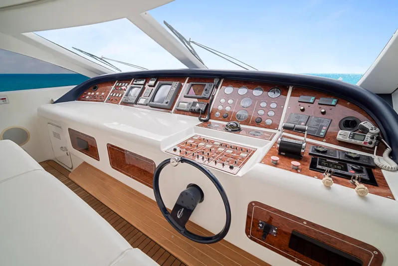 Gabriela G Yacht Photos Pics Cockpit of 2001 Mangusta 72 yacht with wooden dashboard and modern navigation instruments.