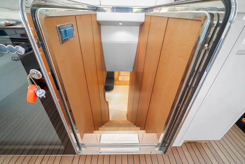 Gabriela G Yacht Photos Pics Staircase leading below deck on 2001 Mangusta 72 yacht, featuring wooden paneling and modern design.