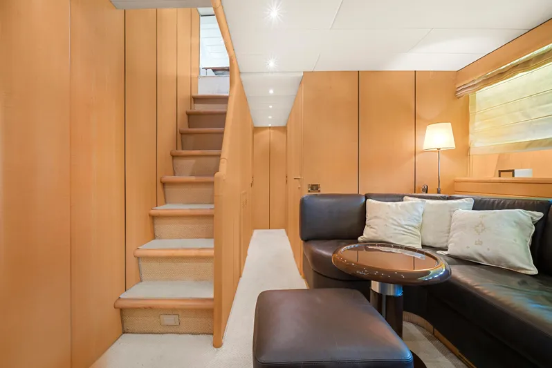 Gabriela G Yacht Photos Pics Luxurious interior of 2001 Mangusta 72 yacht with wooden paneling and cozy seating area.