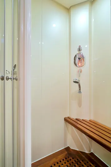 Gabriela G Yacht Photos Pics Luxurious shower area in a 2001 Mangusta 72 yacht with wooden bench seating.