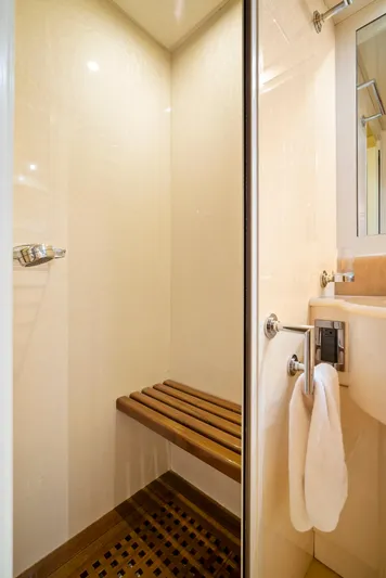 Gabriela G Yacht Photos Pics Shower area in 2001 Mangusta 72 yacht with wooden bench and towel holder.