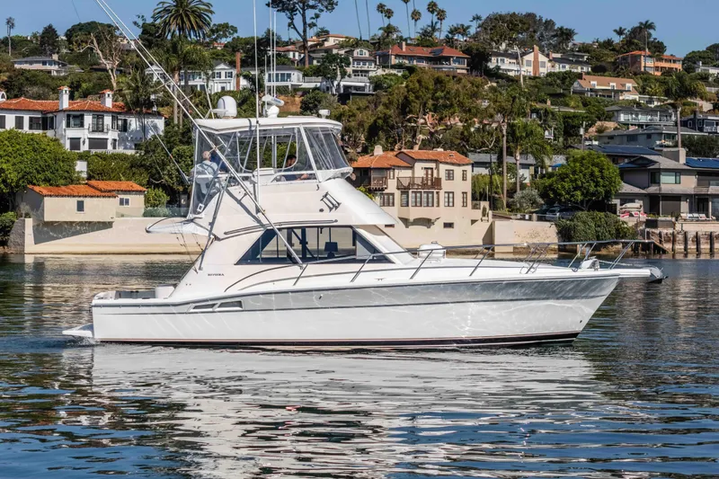 Sunny 1 Yacht Photos Pics 2001 Riviera 36 Flybridge yacht cruising near scenic waterfront homes.