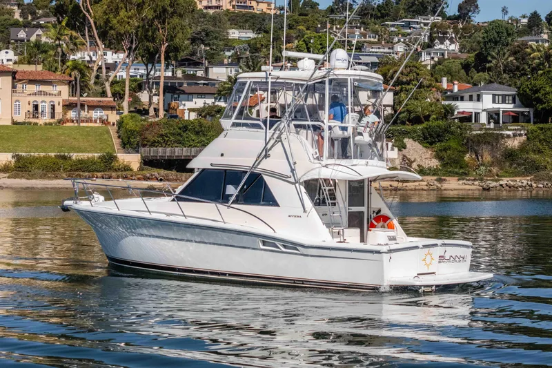 Sunny 1 Yacht Photos Pics 2001 Riviera 36 Flybridge yacht cruising near scenic waterfront homes.