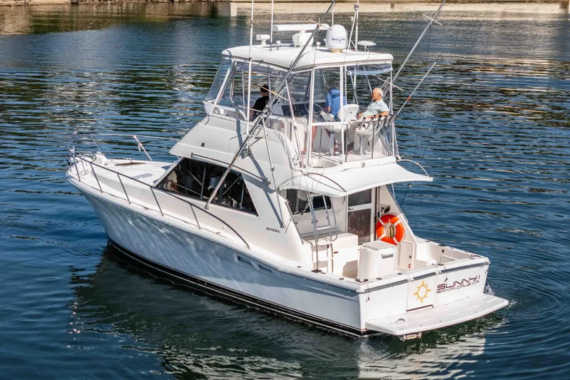 Sunny 1 Yacht Photos Pics 2001 Riviera 36 Flybridge yacht cruising on calm waters.