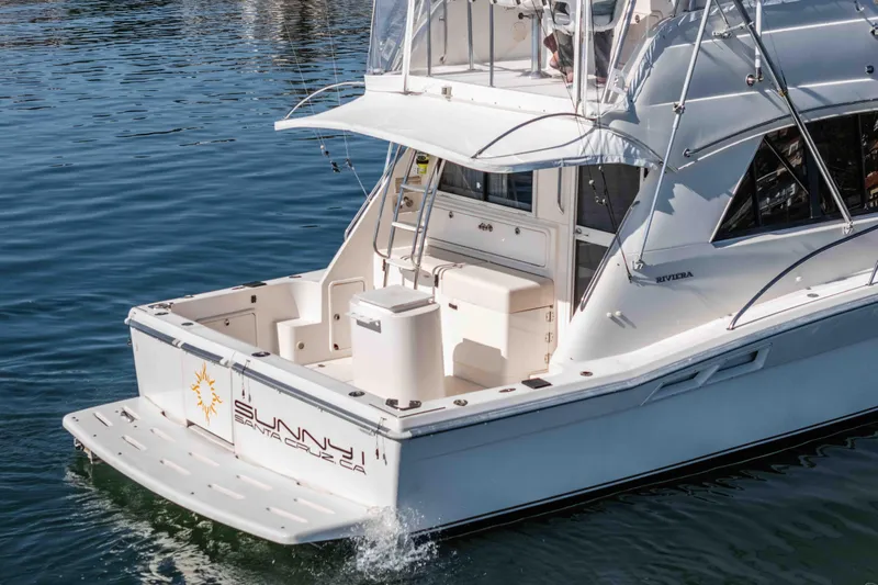 Sunny 1 Yacht Photos Pics 2001 Riviera 36 Flybridge yacht on calm water, rear view.