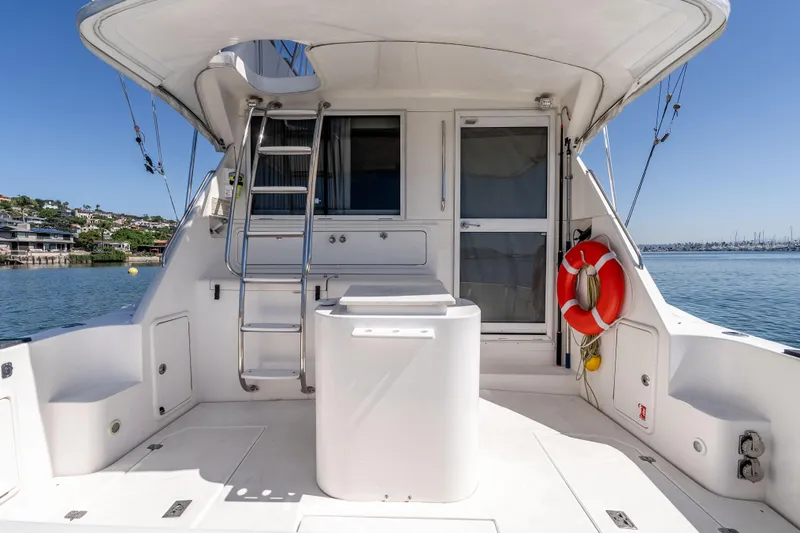 Sunny 1 Yacht Photos Pics 2001 Riviera 36 Flybridge yacht deck with ladder, life preserver, and ocean view.