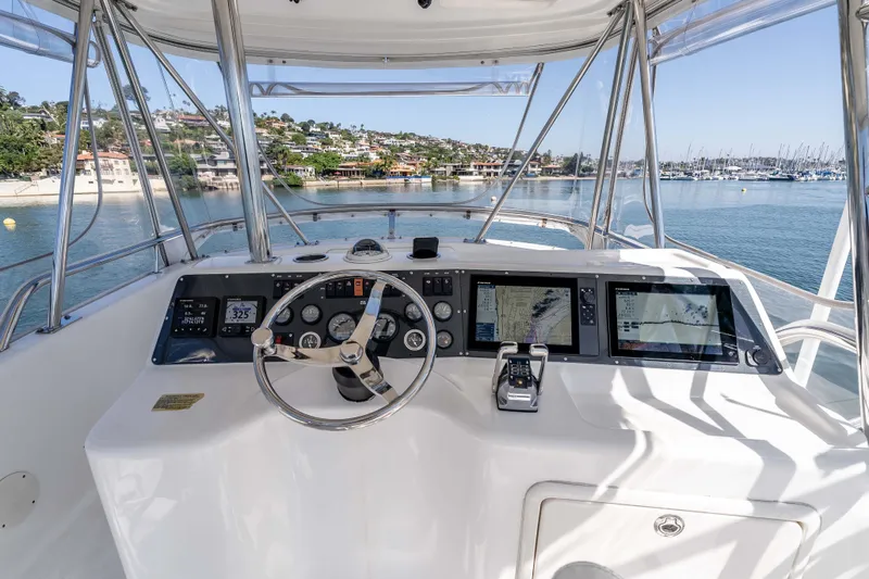 Sunny 1 Yacht Photos Pics Flybridge helm of 2001 Riviera 36 with navigation screens, overlooking marina.