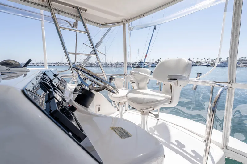 Sunny 1 Yacht Photos Pics Flybridge of 2001 Riviera 36 yacht with steering wheel and white captain's chairs.