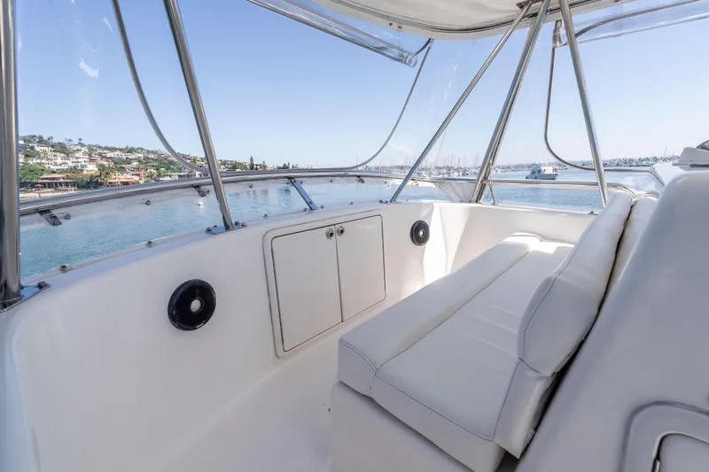 Sunny 1 Yacht Photos Pics 2001 Riviera 36 Flybridge interior with white seating, overlooking scenic waterfront views.
