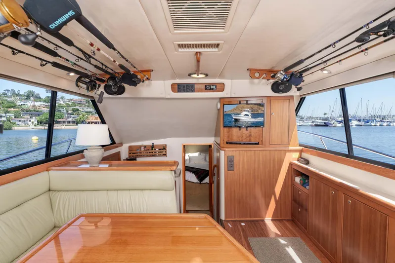 Sunny 1 Yacht Photos Pics Interior of 2001 Riviera 36 Flybridge yacht with fishing rods and scenic marina view.