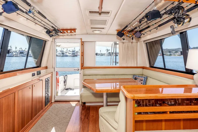 Sunny 1 Yacht Photos Pics Interior of 2001 Riviera 36 Flybridge yacht with fishing rods and waterfront view.